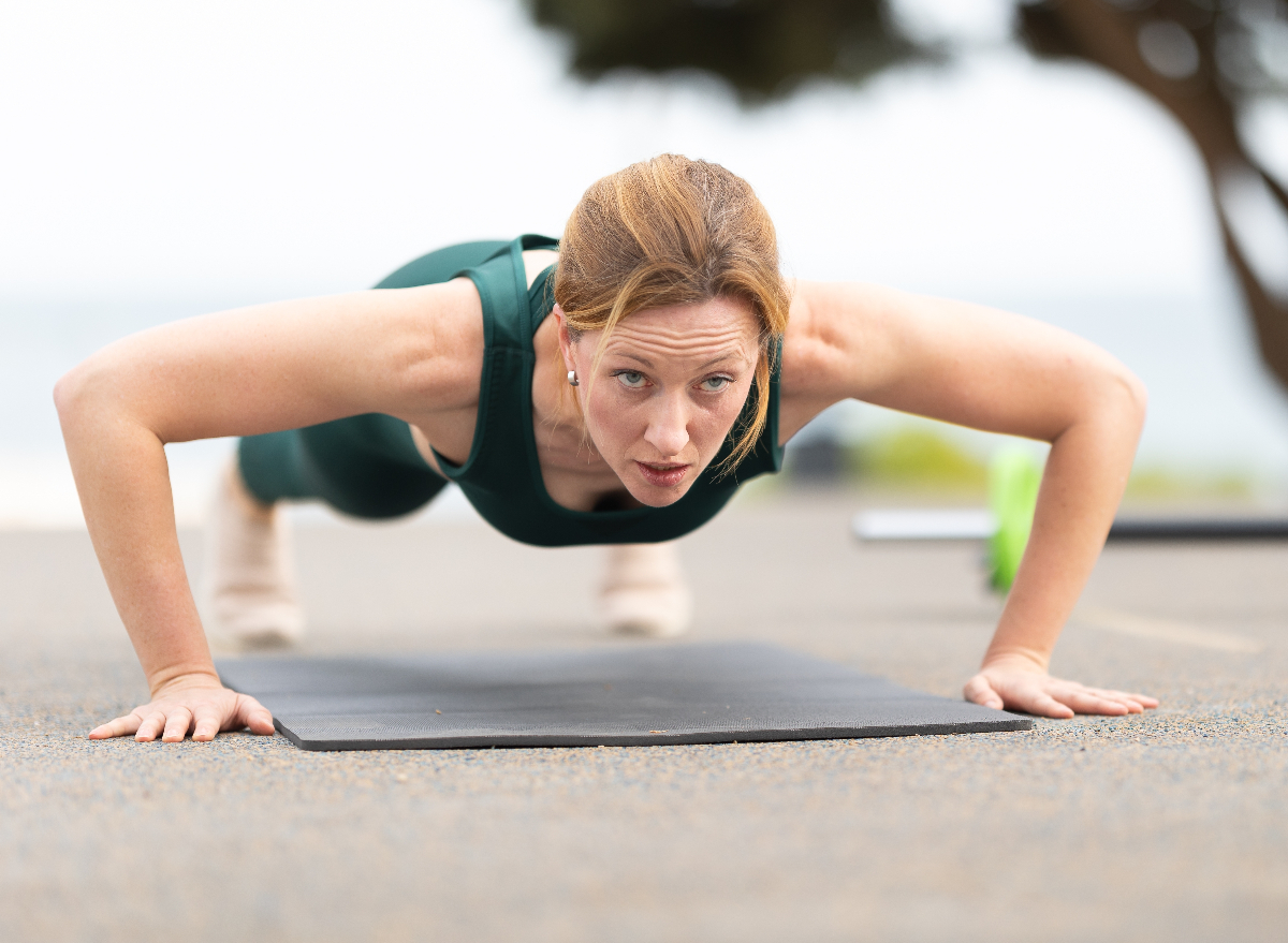 fit middle-aged woman doing pushups, concept of strength exercises for women to look younger
