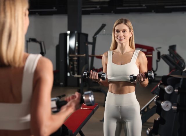 woman doing bicep curls with both arms, concept of free weight exercises to melt armpit pooch