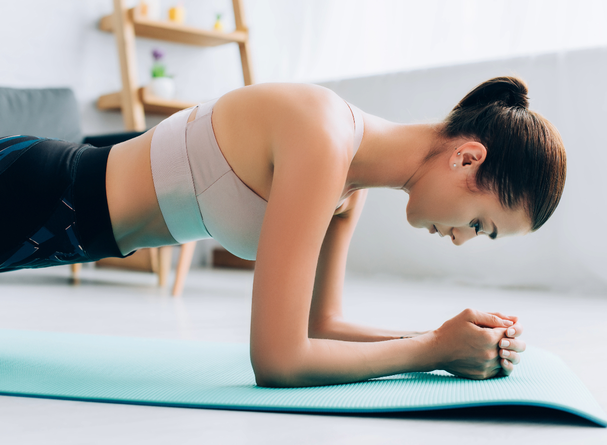 woman doing forearm planks, concept of ab exercises to melt belly fat