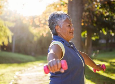 woman holding dumbbells doing standing exercises for faster weight loss after 50