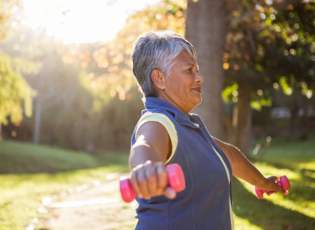 woman holding dumbbells doing standing exercises for faster weight loss after 50