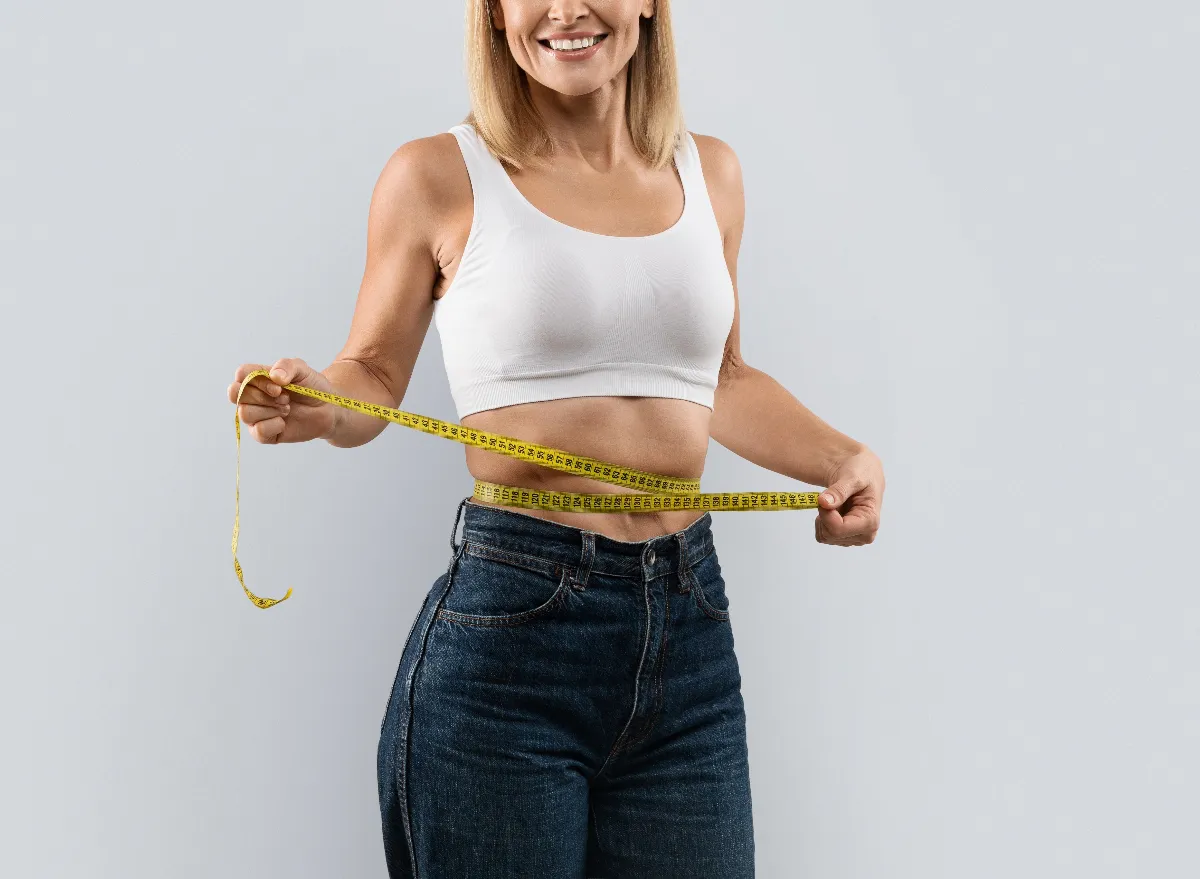 woman measuring her waistline, concept of tips for women to achieve lasting weight loss after 40