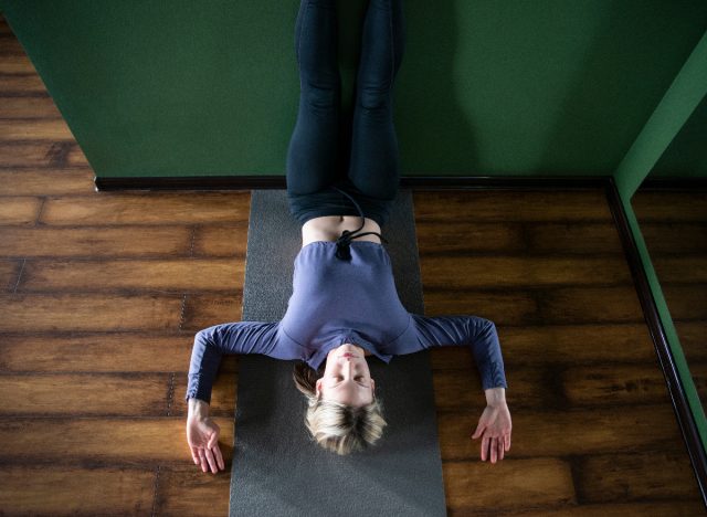 woman yoga release wall stretch