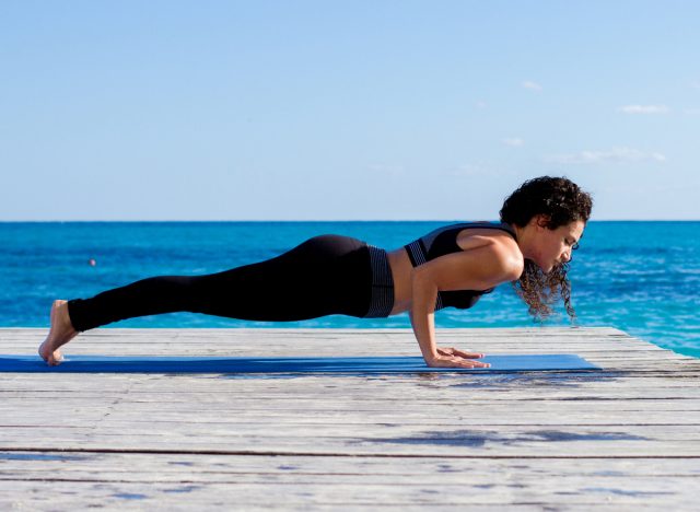 woman doing Chaturanga, concept of yoga exercises to reduce arm fat