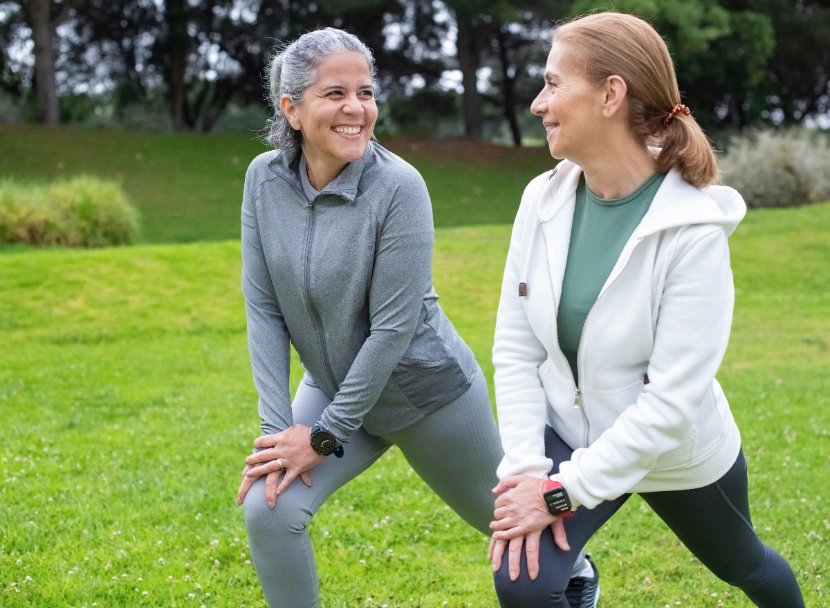 mature friends stretching, warming up for exercise together. concept of workout habits to live longer