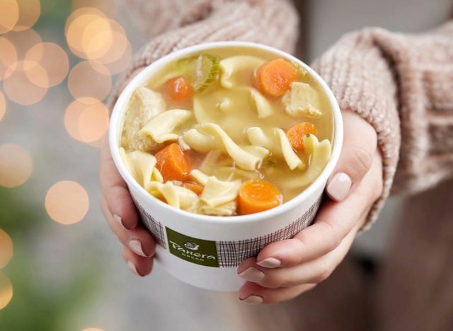person holding panera chicken noodle soup