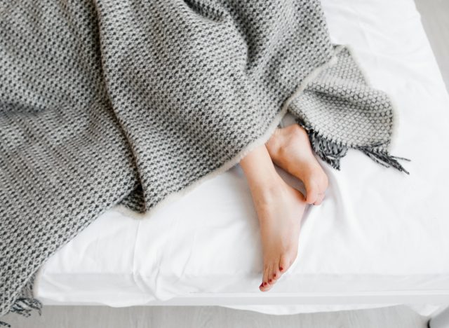 woman cricketing or rubbing feet together in bed