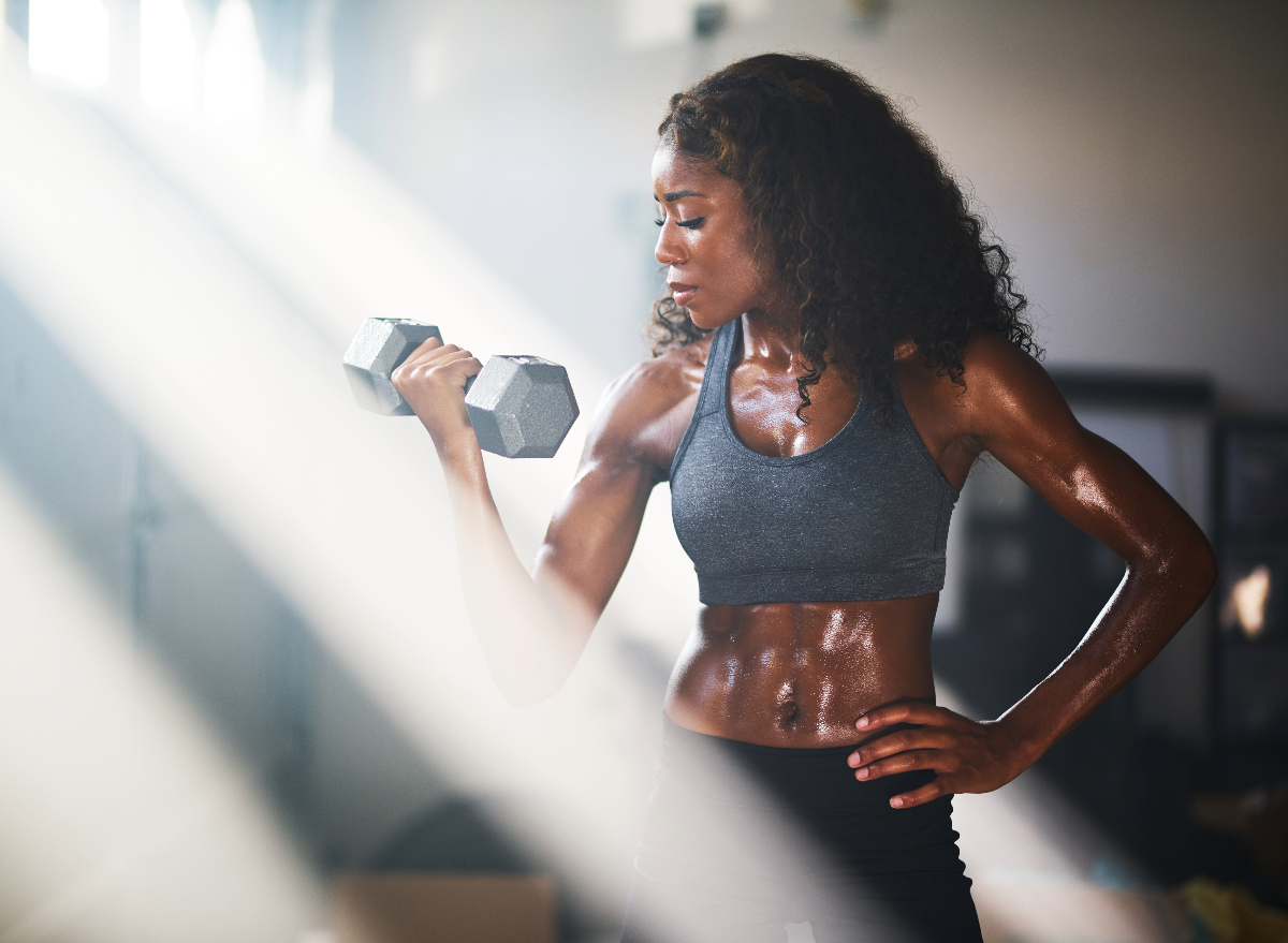 woman lifting dumbbell, concept of fitness tips for women to prevent muscle loss