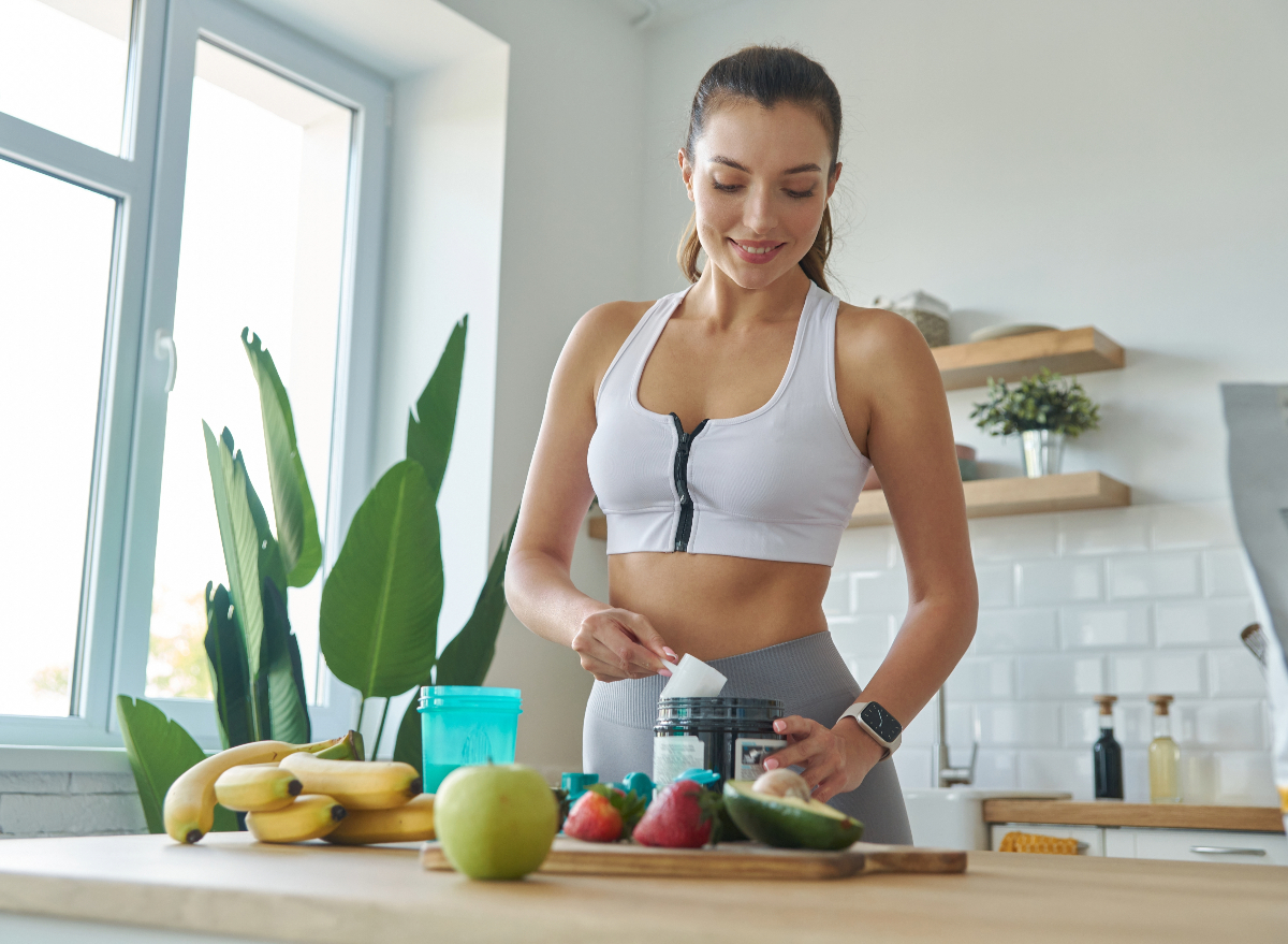 woman making protein drink, concept of sneaky ways to build muscle without exercising