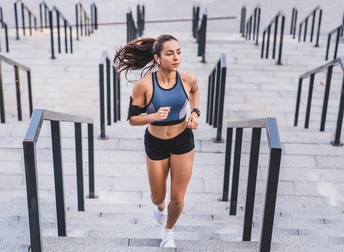 woman running up steps, concept of tips to avoid belly fat