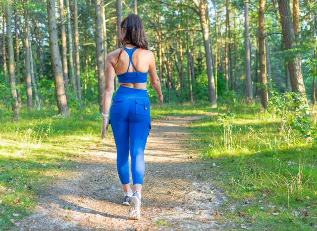 woman walking on trails, concept of daily walking workout for women to get fit