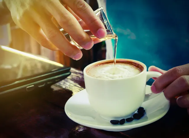 pouring syrup in to Latte hot coffee cup.