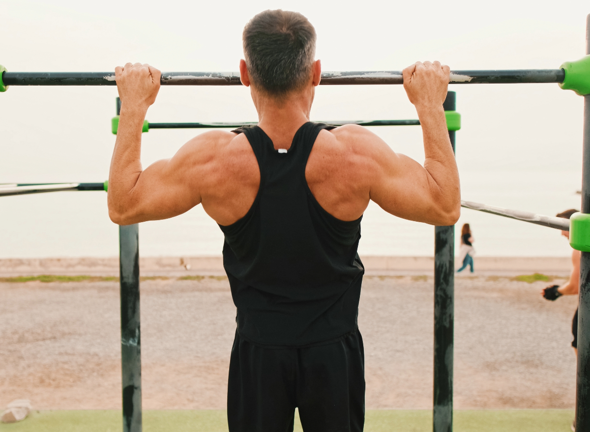 man doing pull-ups, concept of strength exercises to slow muscle aging