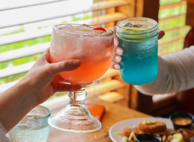 people holding logan's roadhouse cocktails