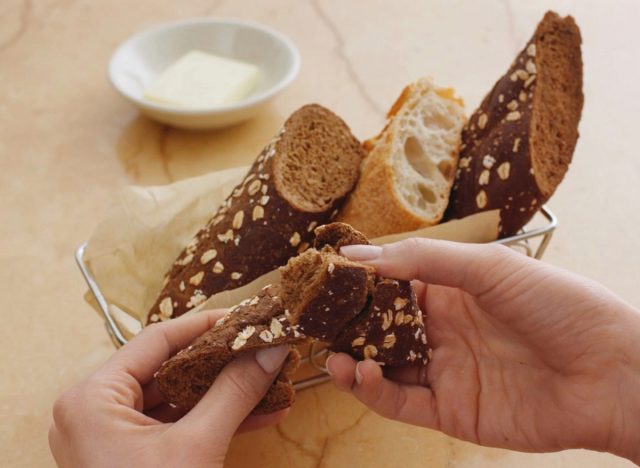 person holding cheesecake factory bread over bread basket