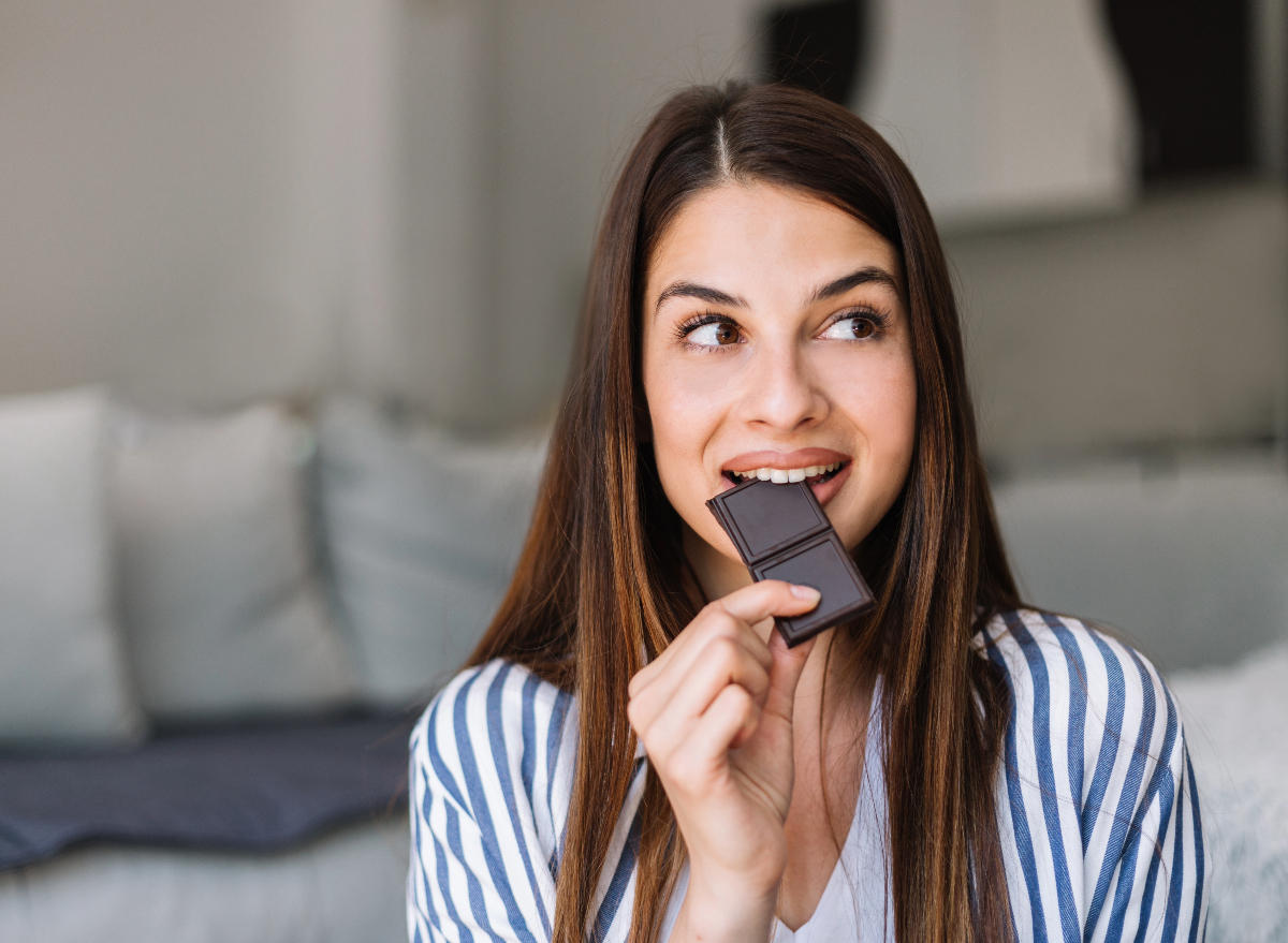 woman eating dark chocolate, concept of bad foods that help weight loss