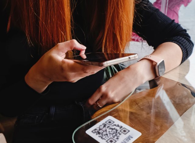 woman scanning QR code at restaurant