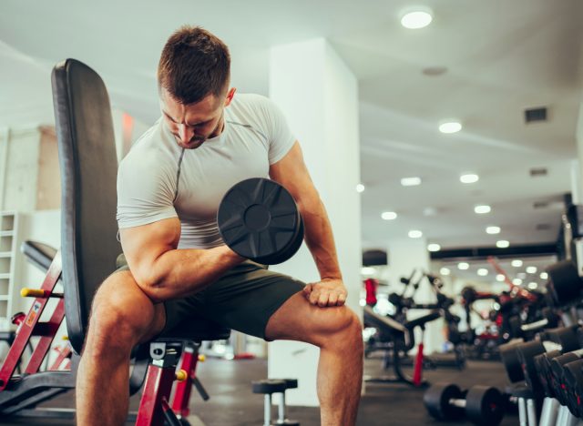 man doing dumbbell curls, concept of habits that damage body