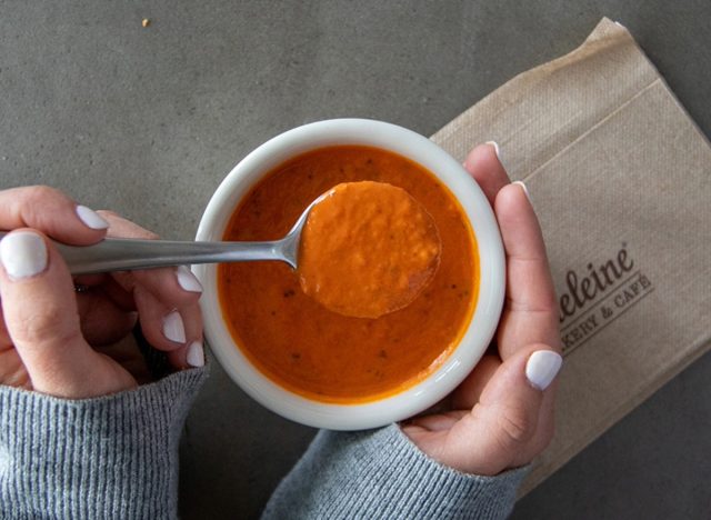 person holding la madeleine tomato basil soup