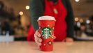 starbucks employee holding reusable red cup
