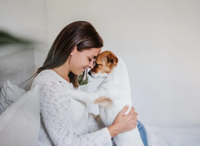 woman cuddling with her puppy