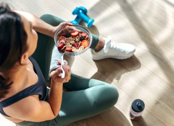woman eating hearty breakfast before workout, concept of ways to burn an extra 100 calories a day