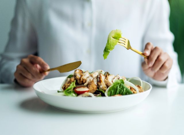 woman eating salad with chicken, concept of food sequencing for weight loss