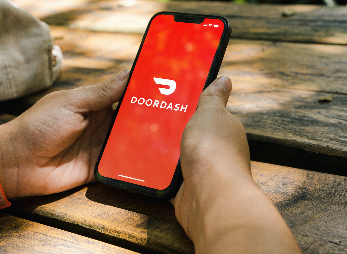 woman holding phone with doordash app open on it