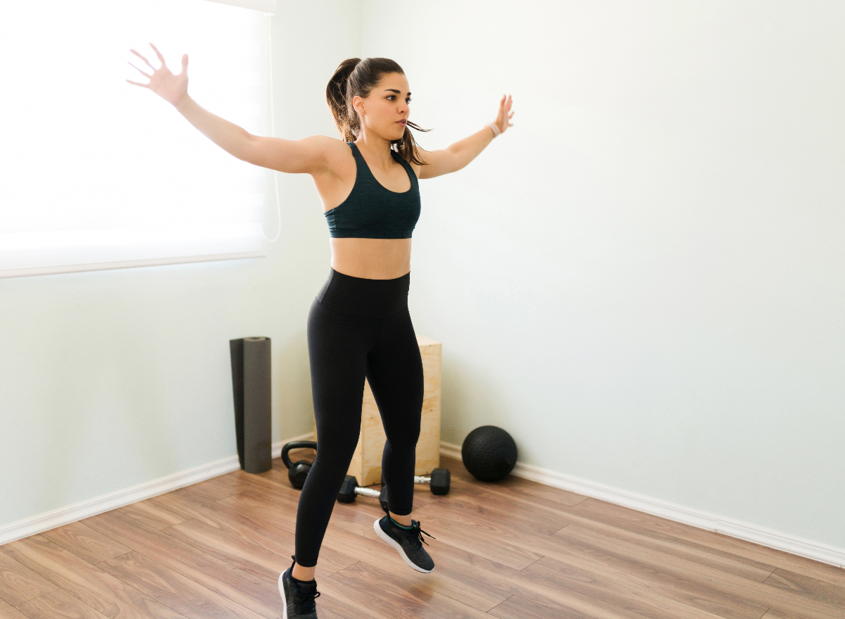 woman doing jumping jacks, concept of exercises to stay fit when short on time