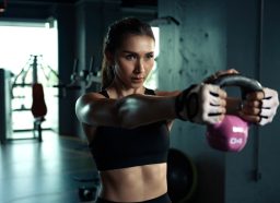 woman holding kettlebell, concept of HIIT workout for belly fat