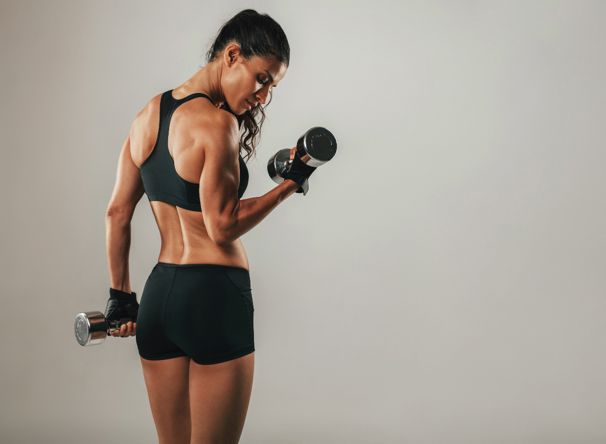 woman lifting dumbbells, concept of how to get slim waist and improve strength