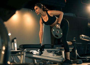 woman lifting weights, concept of how long to work out for results