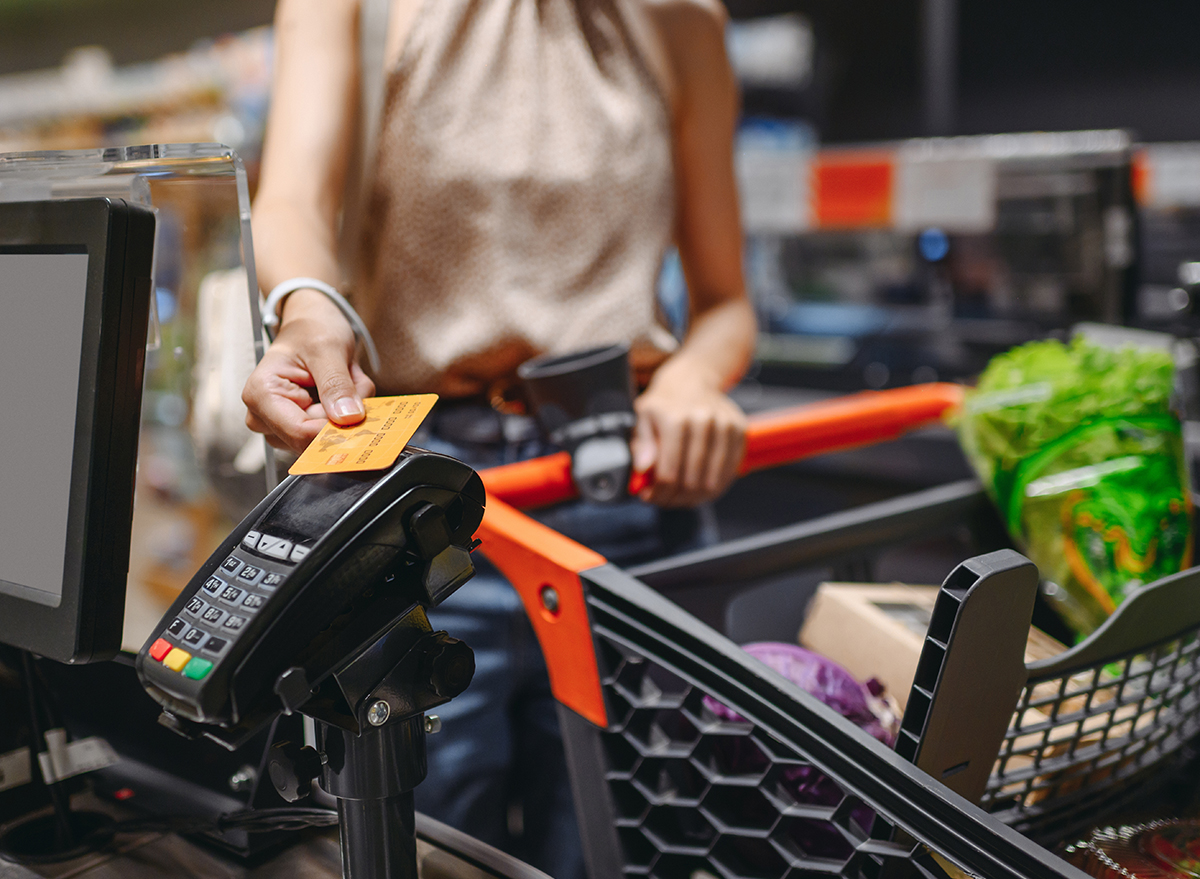 Woman paying at supermarket checkout