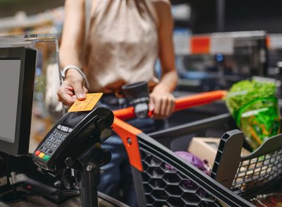 Woman paying at supermarket checkout