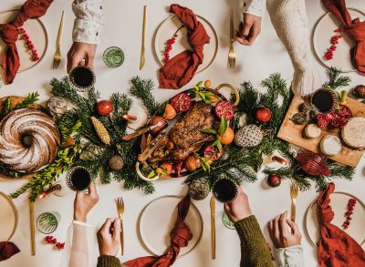 Christmas dinner table, people toasting, concept of mindful holiday eating tips