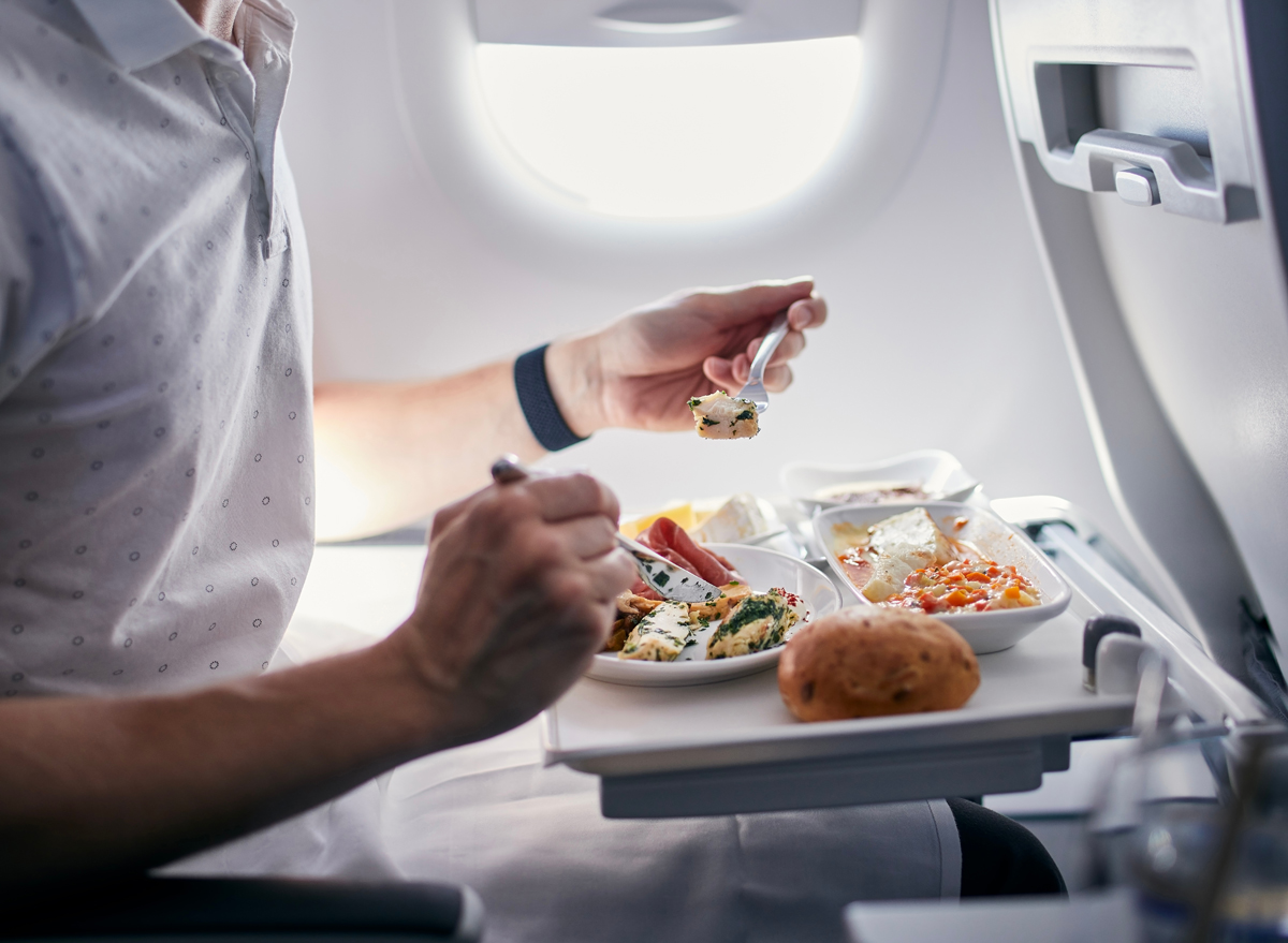 man eating food on a plane