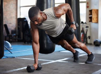 man doing dumbbell renegade row, concept of exercises to build bigger muscles