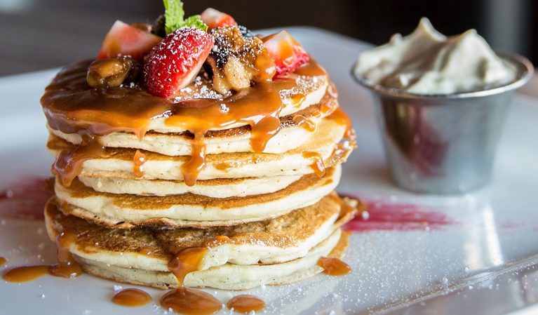 Pancakes loaded with caramel strawberries and chocolate
