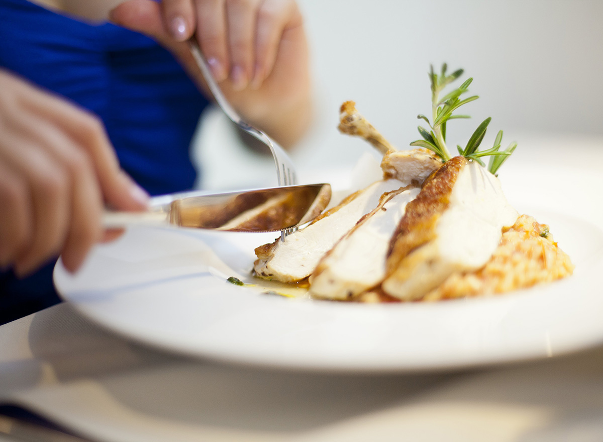 Eating,Chichen,From,Plate,With,Fork,And,Knife,Woman,Hands