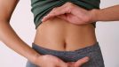 woman cupping her stomach, concept of navel oiling to lose weight