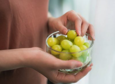 woman holding grapes, concept of can eating grapes help you lose weight