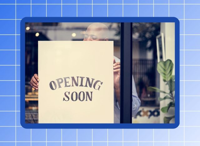 Photo of man hanging "opening soon" sign on a window against a blue background