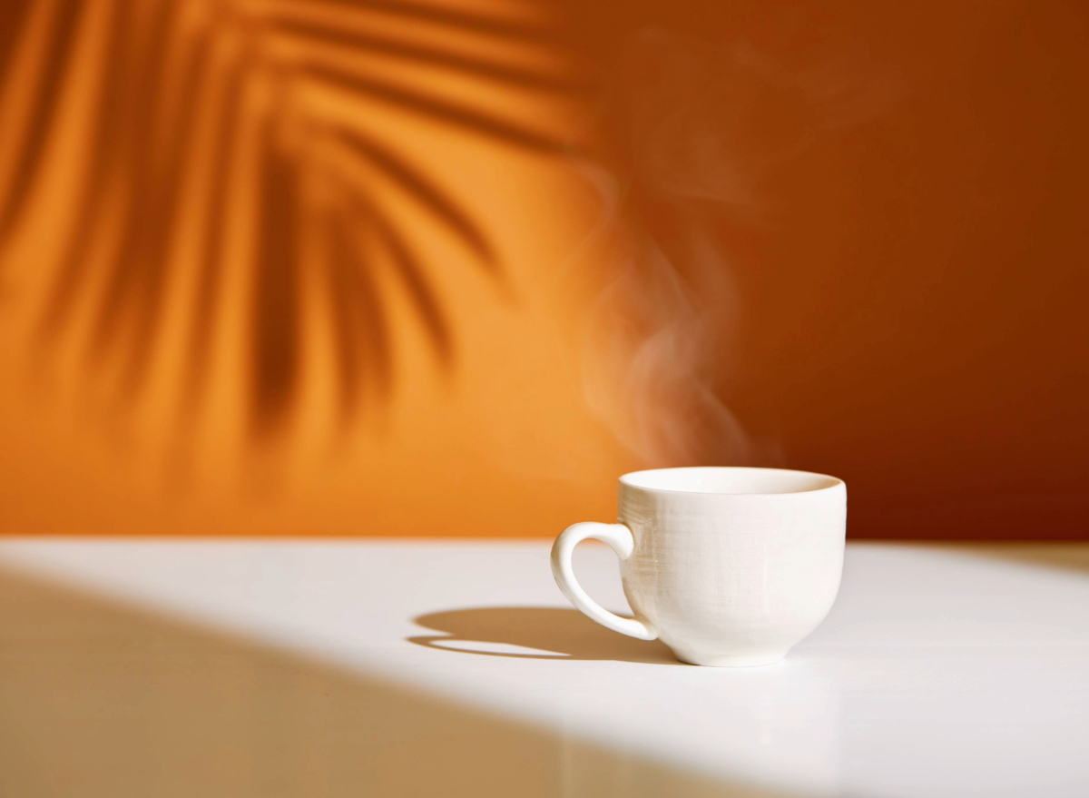 steaming cup of coffee on counter, concept of how many cups of coffee to drink daily for weight loss