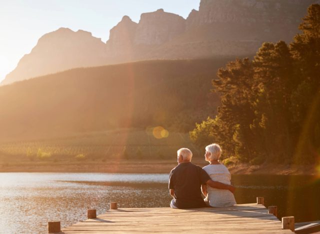 mature couple relaxing by lake at sunset, concept of U.S. states that are most likely to become blue zones