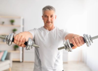 mature man doing dumbbell exercise, concept of free weight exercises to improve balance