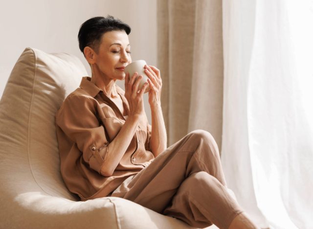 mature woman drinking tea, concept of how many cups of tea to drink to slow aging