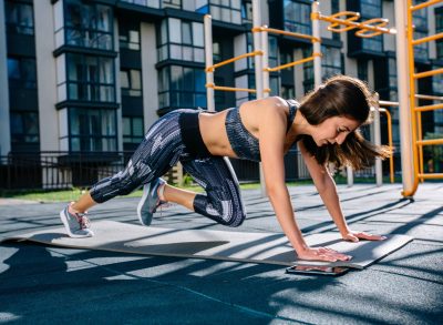 fit woman doing mountain climbers exercise outdoors, concept of morning floor workouts for weight loss