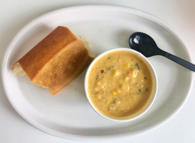 panera bread mexican corn chowder on a plate with a spoon and a pice of bread
