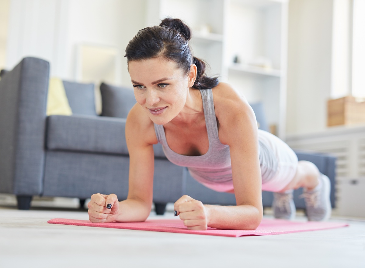 woman doing plank exercise, concept of at-home strength workouts for belly fat