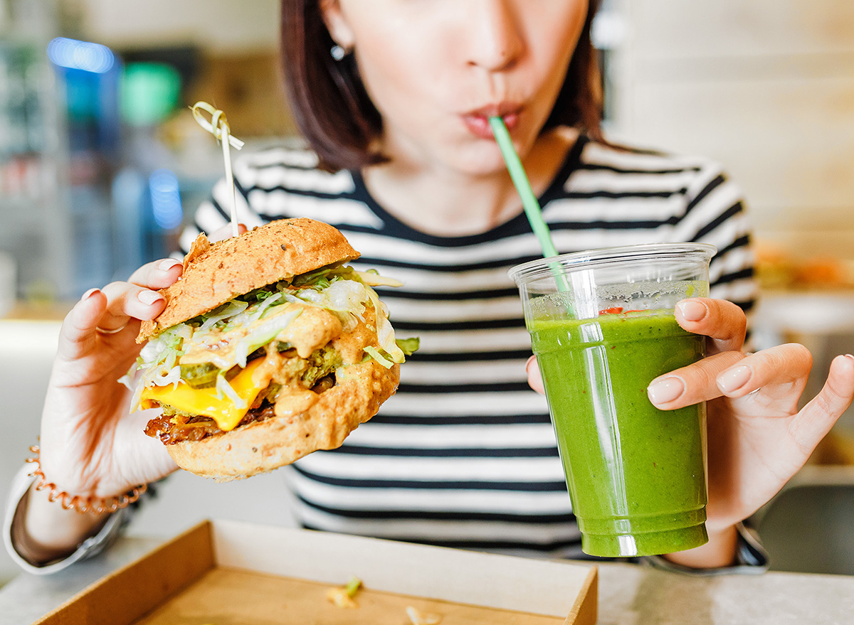 Vegan, fast food,A,Young,Woman,Drinks,Green,Smoothies,And,Eats,A,Burger
